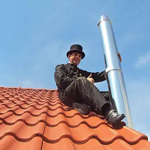 Ramoneur avec conduit de cheminée en acier inoxydable sur le toit