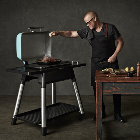 Mann grillt auf einem Everdure Force Mint Gasgrill Mann grillt auf einem Everdure Force Mint Gasgrill
