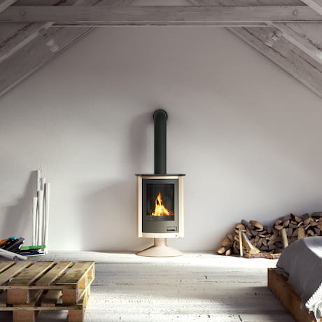 Poêle à bois compact dans un grenier cosy avec des bûches empilées